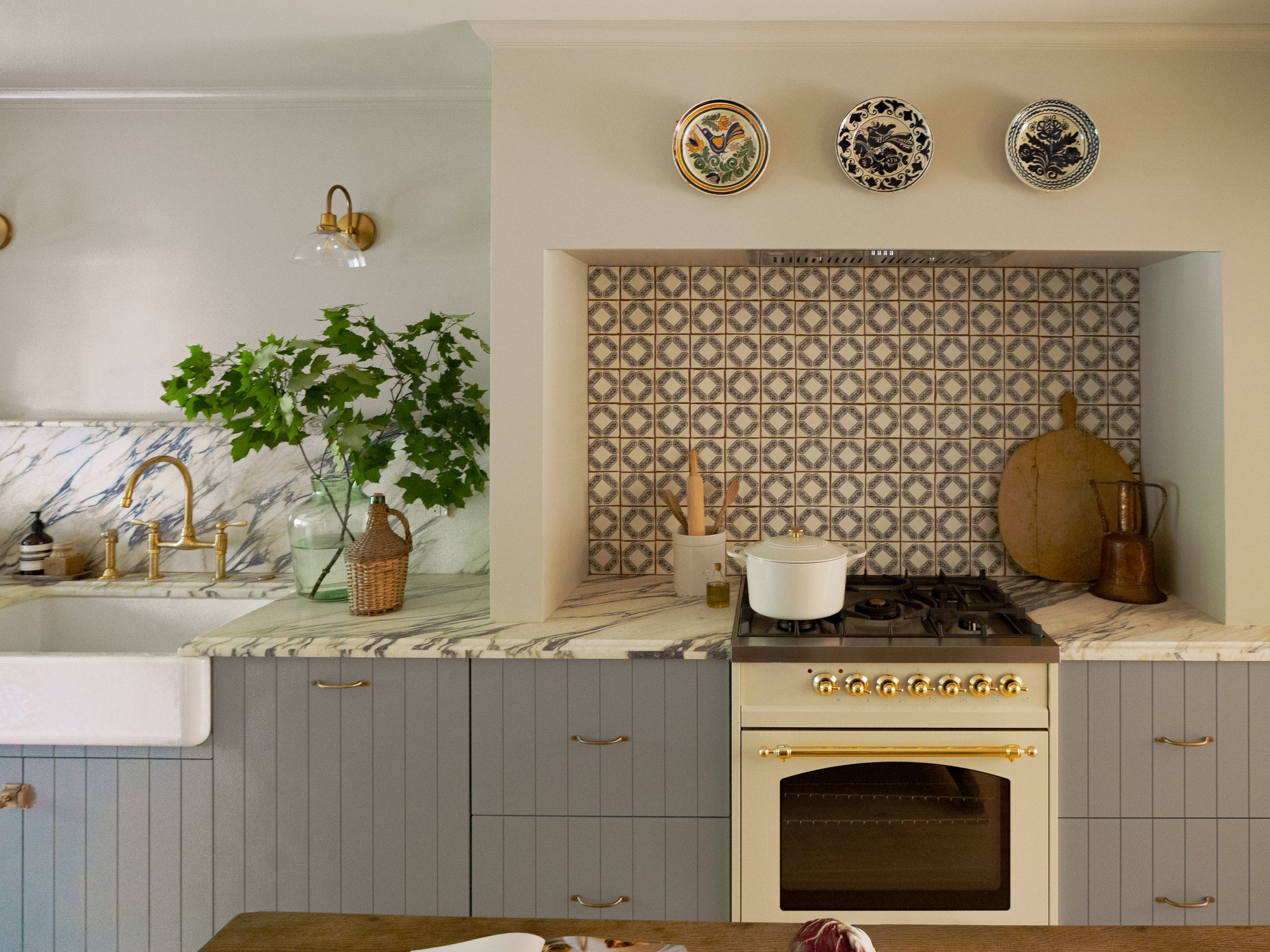 Parisian-inspired kitchen range nook with hand-painted tile and antique plates in Harbor House, Westport, Connecticut