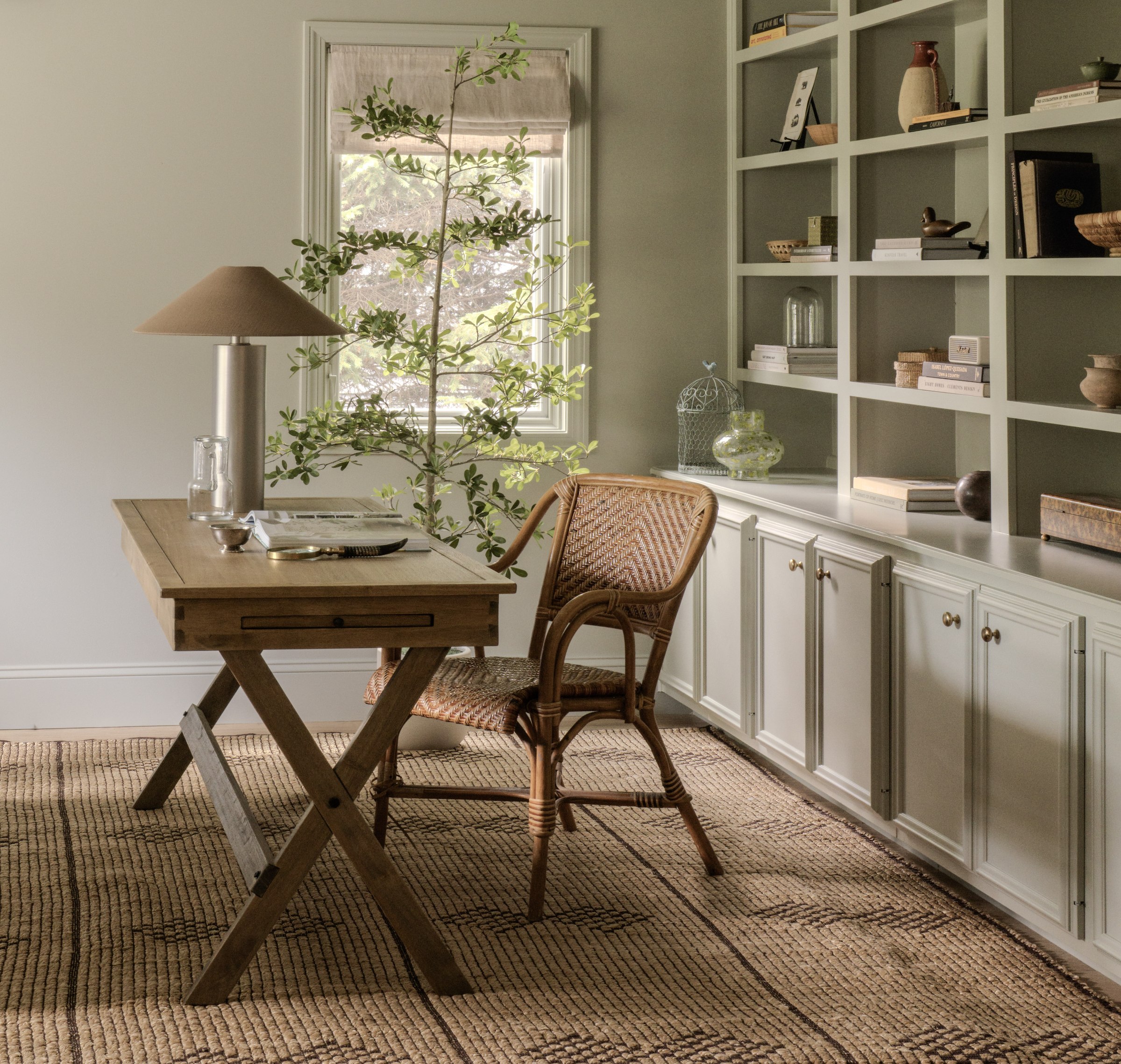Collected study with built-in bookshelves and rattan chair in the Harbor House project in Westport, Connecticut